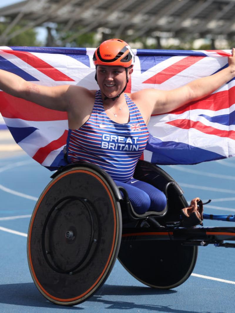 Wheelchair racer Eden Rainbow-Cooper holds up the Great Britain flag in celebration