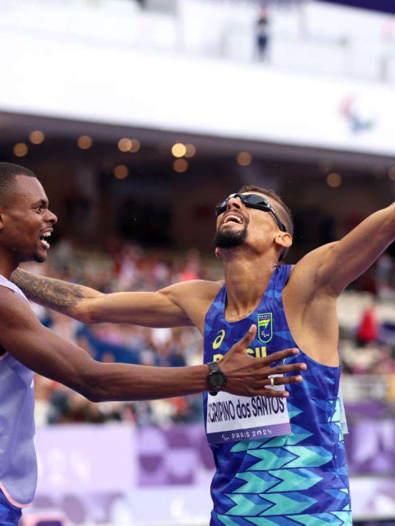 Agripinos dos Santos and his guide raise their arms in celebration