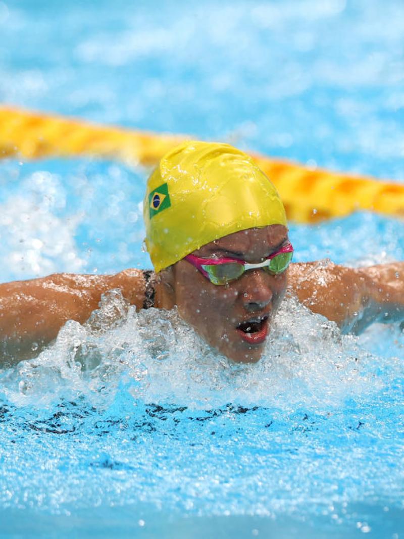 Brazilian swimmer Maria Carolina Santiago competes. She is wearing a yellow swimming cap and pink goggles