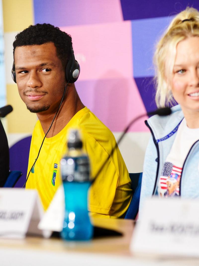 Two men and a woman at a press conference table
