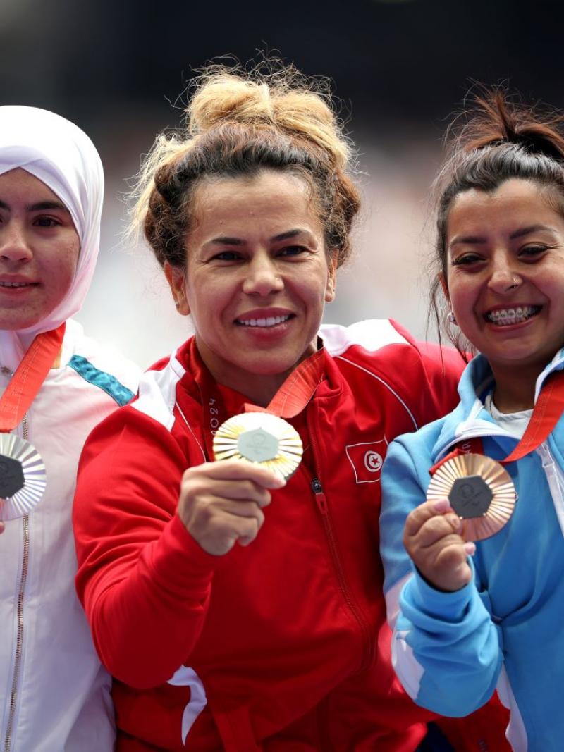 Three female short statures athletes showing their medals