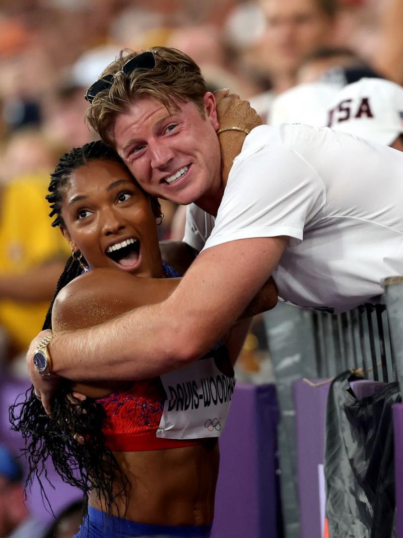 A female athlete hugging a man on trackside