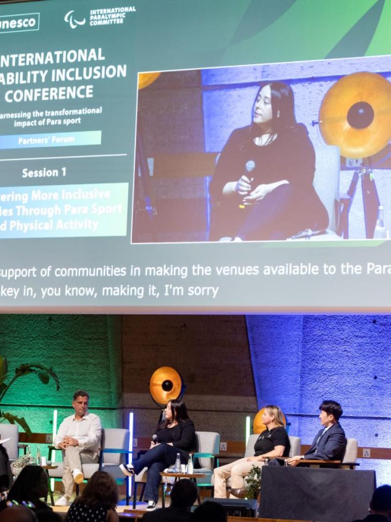 Five persons speaking to the public in a conference