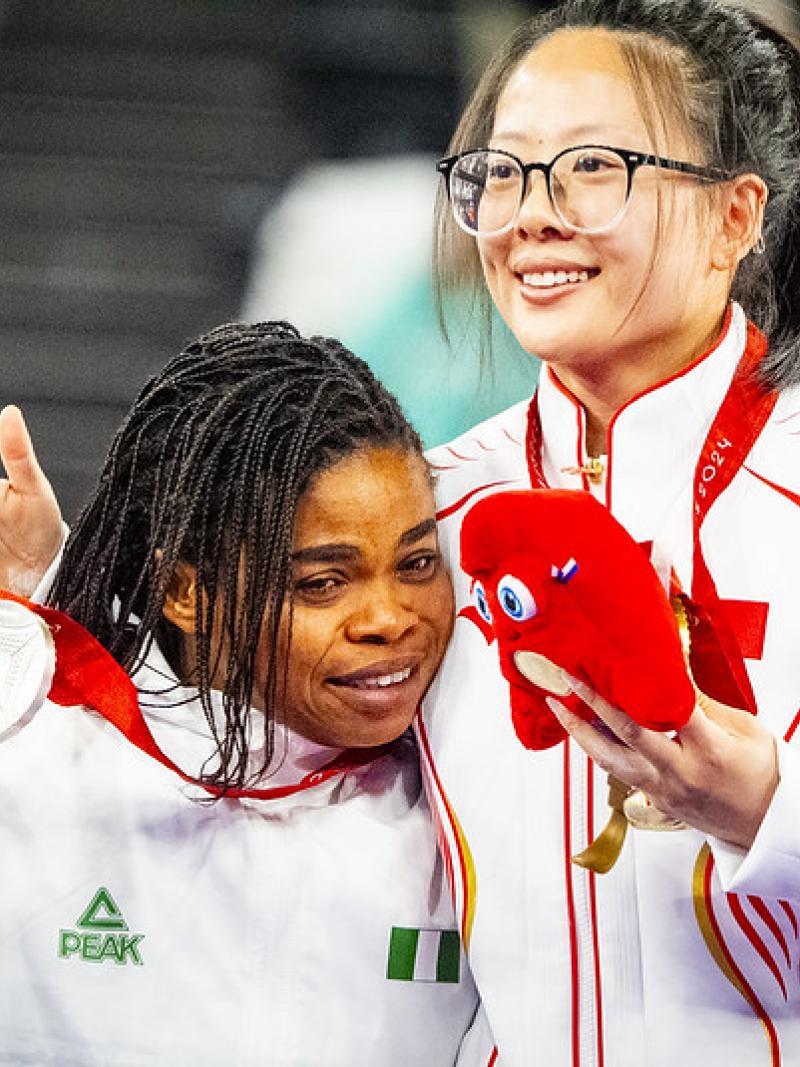 Two female athletes hugging with their medals
