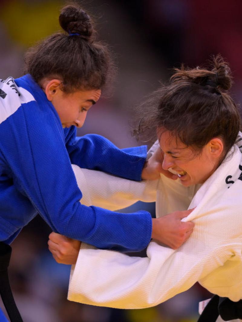 Two woman competing in Para judo grab each other by the arms