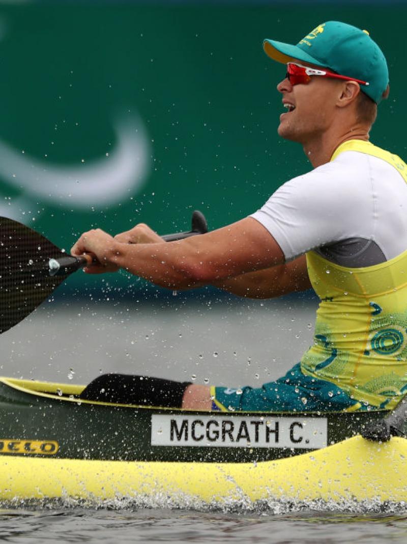 A man in a Team Australia uniform sits in a kayak and prepares to put his oar back in the water 