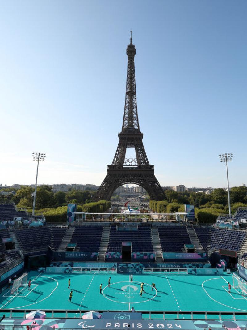 An outdoor blind football stadium, with the Eiffel Tower in the background