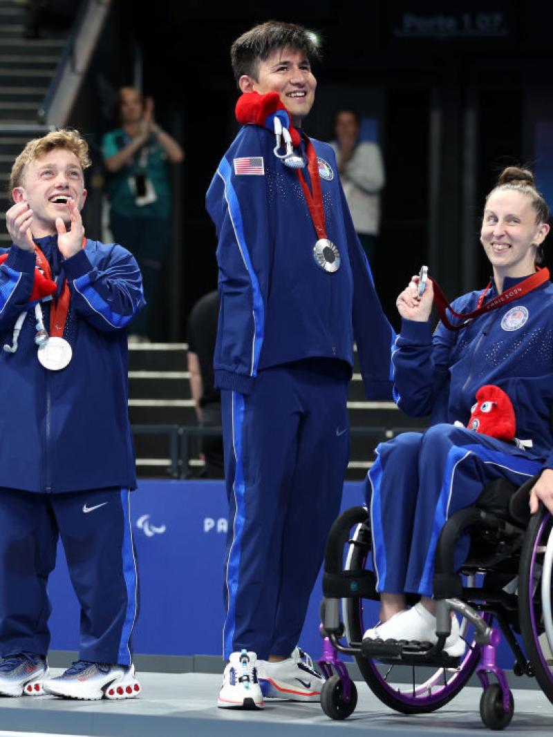 A group of USA Para swimmers smiling on the podium 