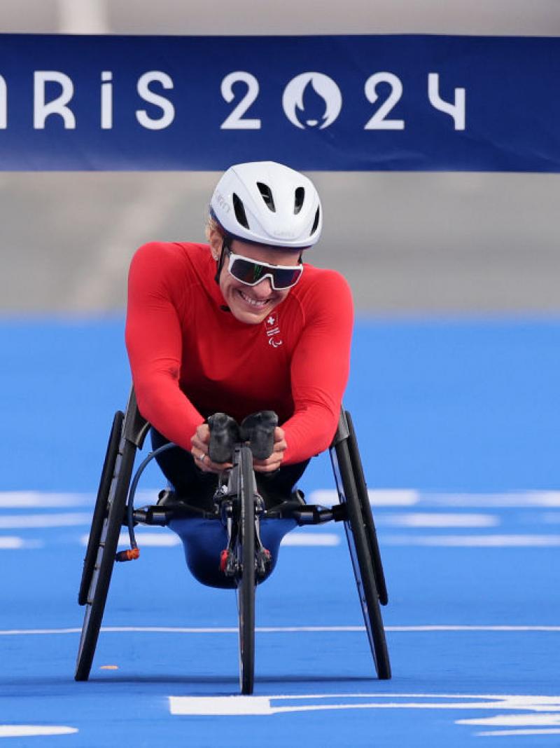 A female wheelchair racer crossing the finish line of the Paris 2024 marathon