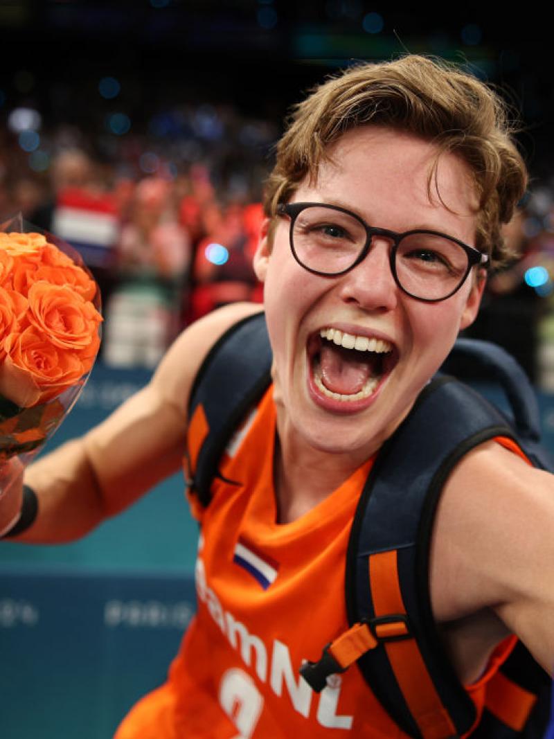 Bo Kramer celebrates into the camera while holding orange flowers