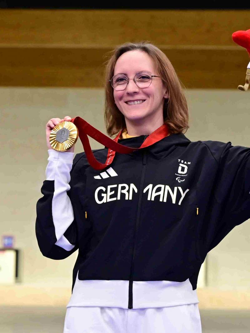 A shooter celebrates her medal