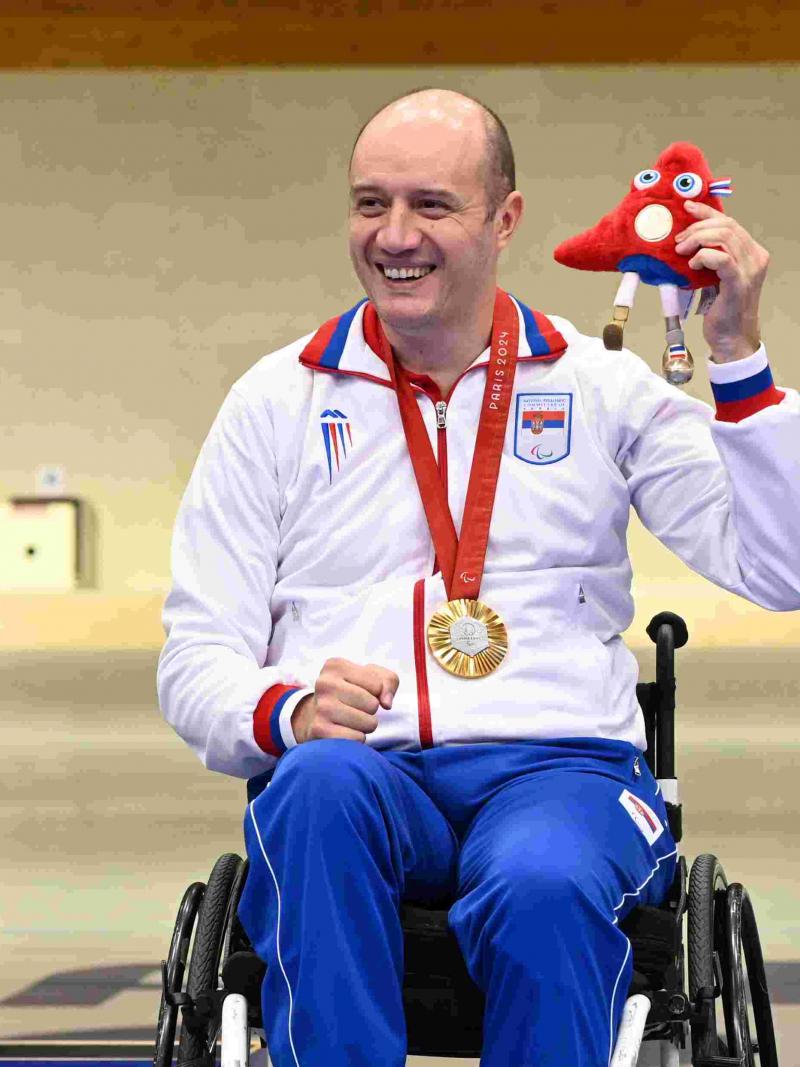 An athlete poses on podium