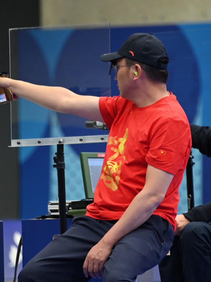 Two male shooters in a pistol event in a shooting range