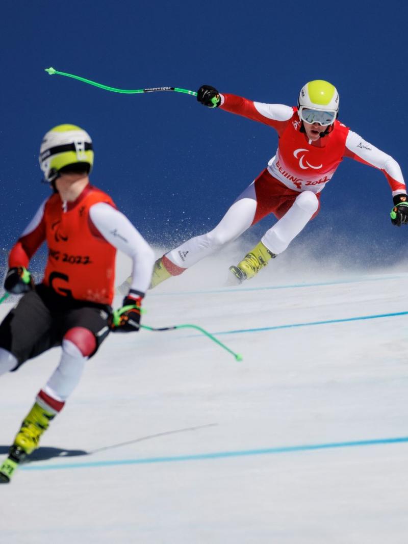 A male alpine skier follows his guide skier during competition