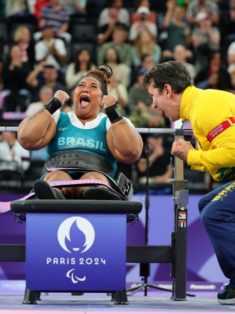Tayana Medeiros pumps her fist after a successful lift
