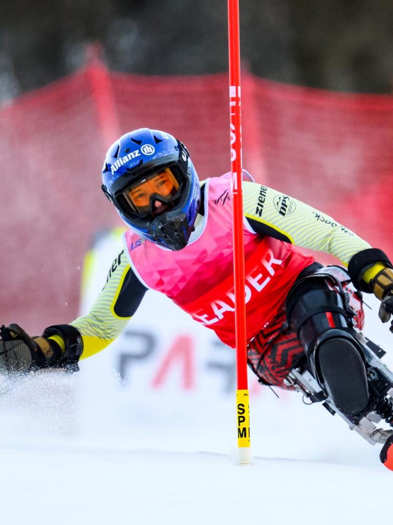 A female Para alpine sit skier is in action