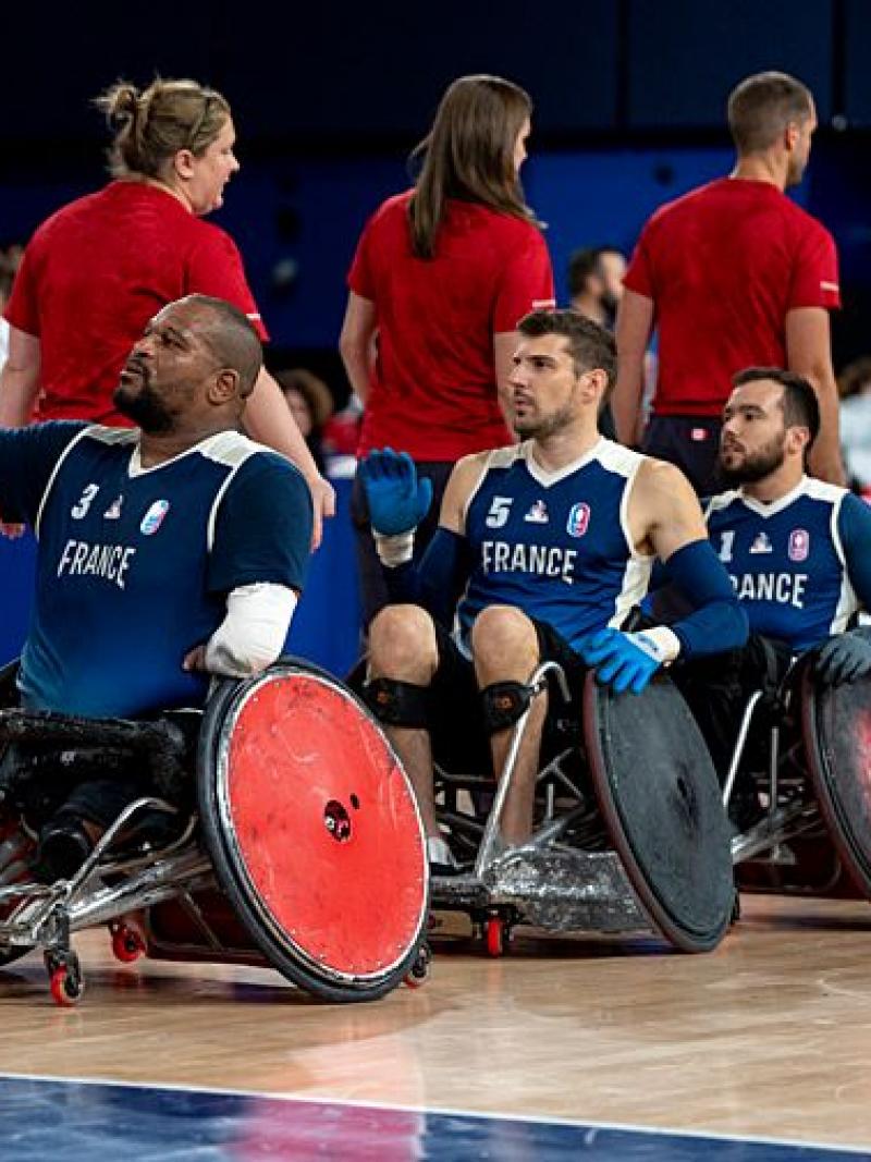 Four wheelchair rugby players form a line to shake hands with officials