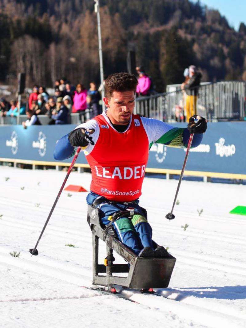 A male athlete is competing on a sit-ski