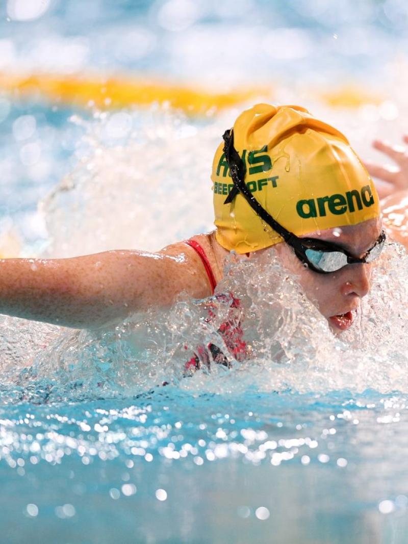 A female athlete with the cap of Australia swimming butterfly