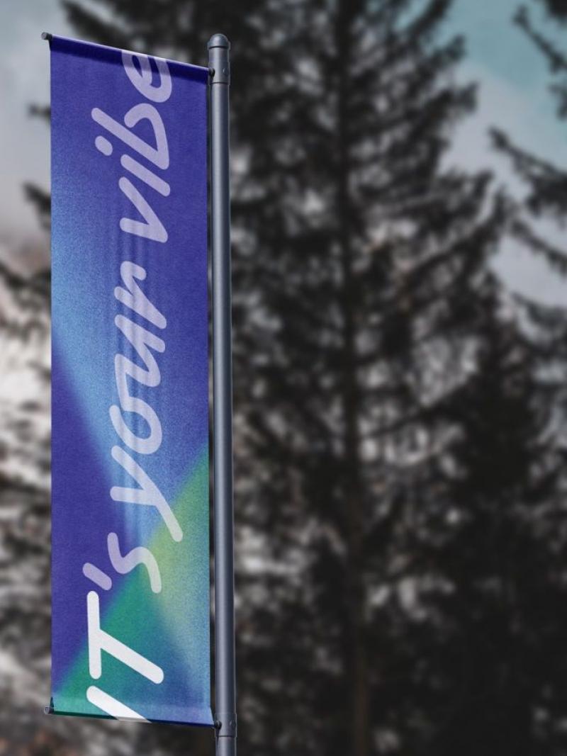 A photo of four blue and green flags in front of a mountain. 