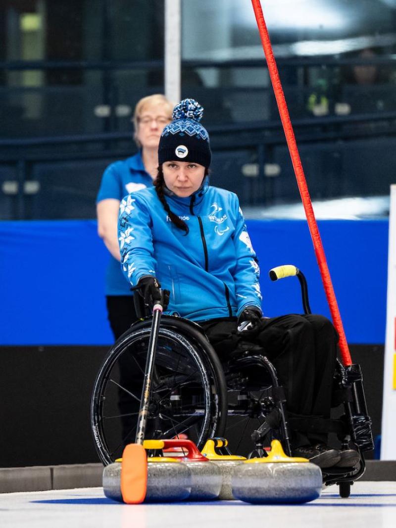 Female wheelchair curling athlete in action