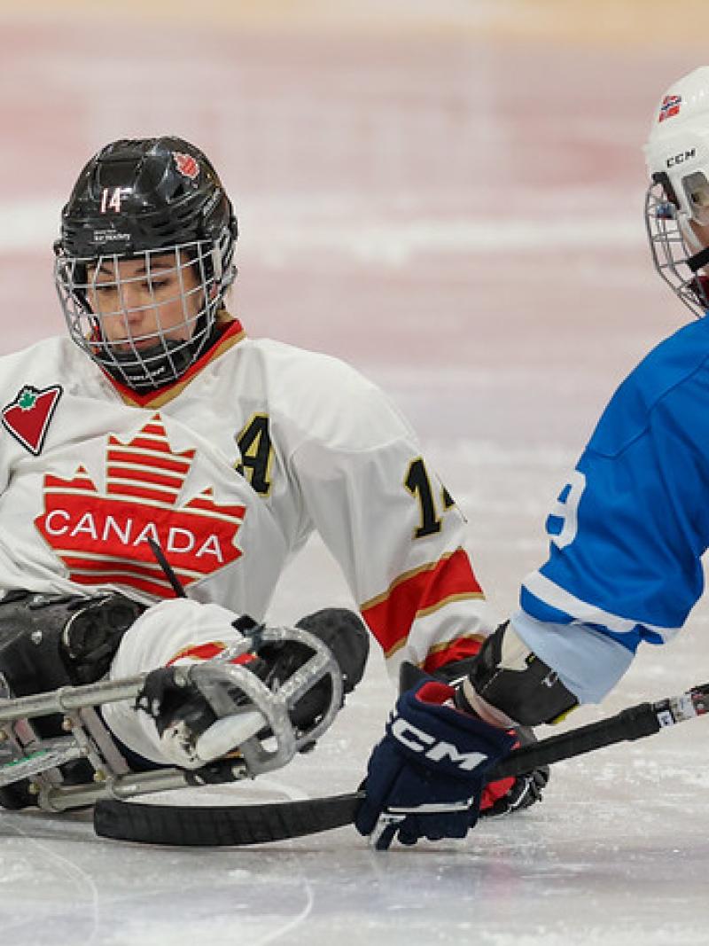 Two female Para ice hockey players in a game