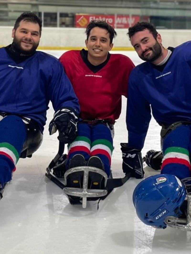 Three male Italian Para ice hockey athletes posing on the ice