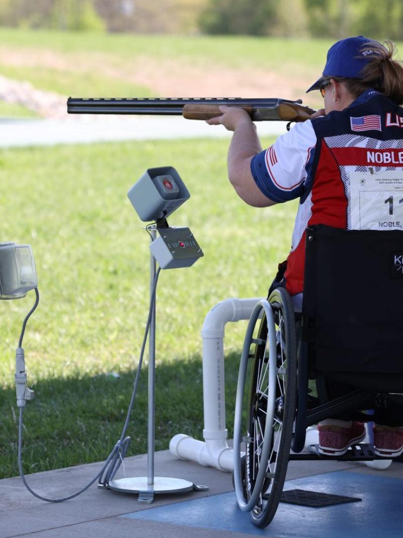 A female Para trap shooter in a wheelchair during a competition