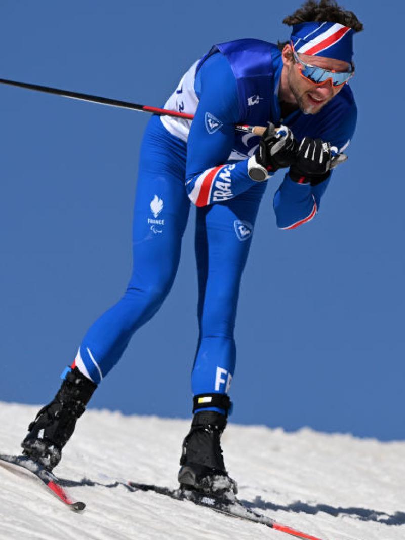 A male Para biathlon athlete is competing in cross-country skiing