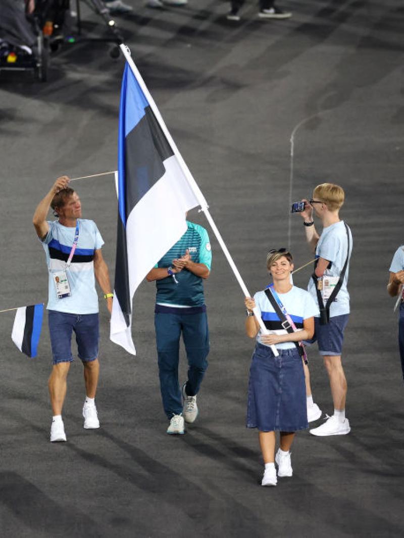 Seven male and female athletes take part in the Parade Of Nations at the Paris 2024 Opening Ceremony. A female athlete is carrying the Estonian flag.