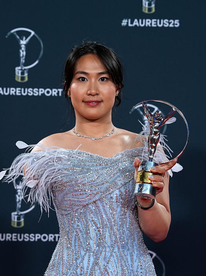 Yuyan Jiang smiles for a photo while holding the Laureus trophy with her left hand