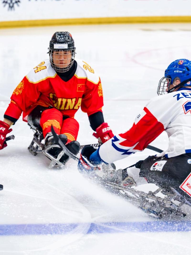 A Chinese Para ice hockey player in front of a Czech player