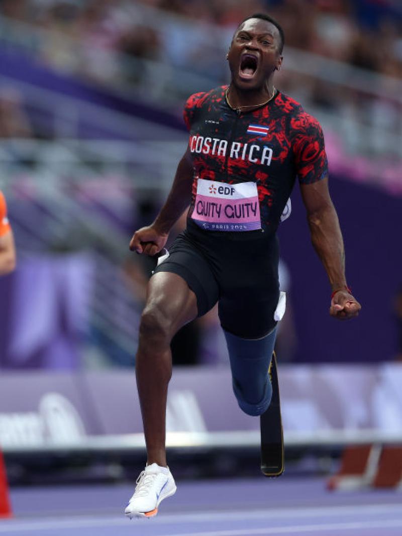 Three male athletes with prosthetic legs in a Para athletics race