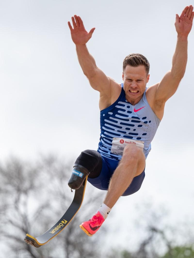 A man with a prosthetic leg competing in the long jump
