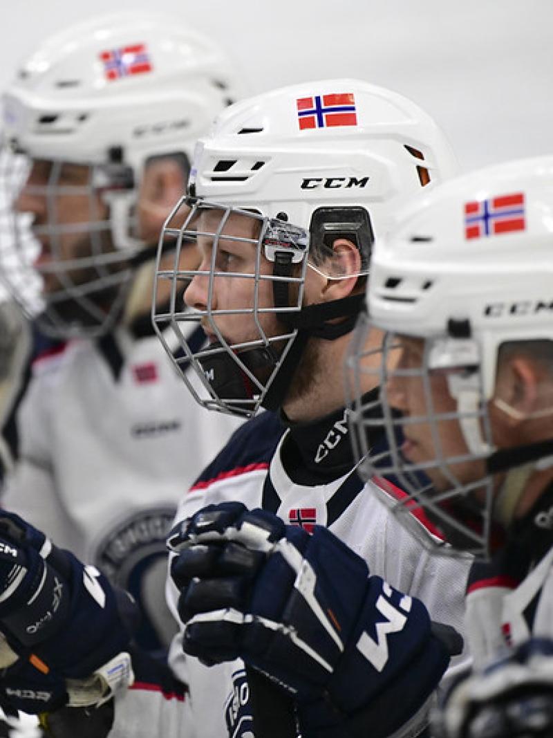Three male Para ice hockey players looking straight