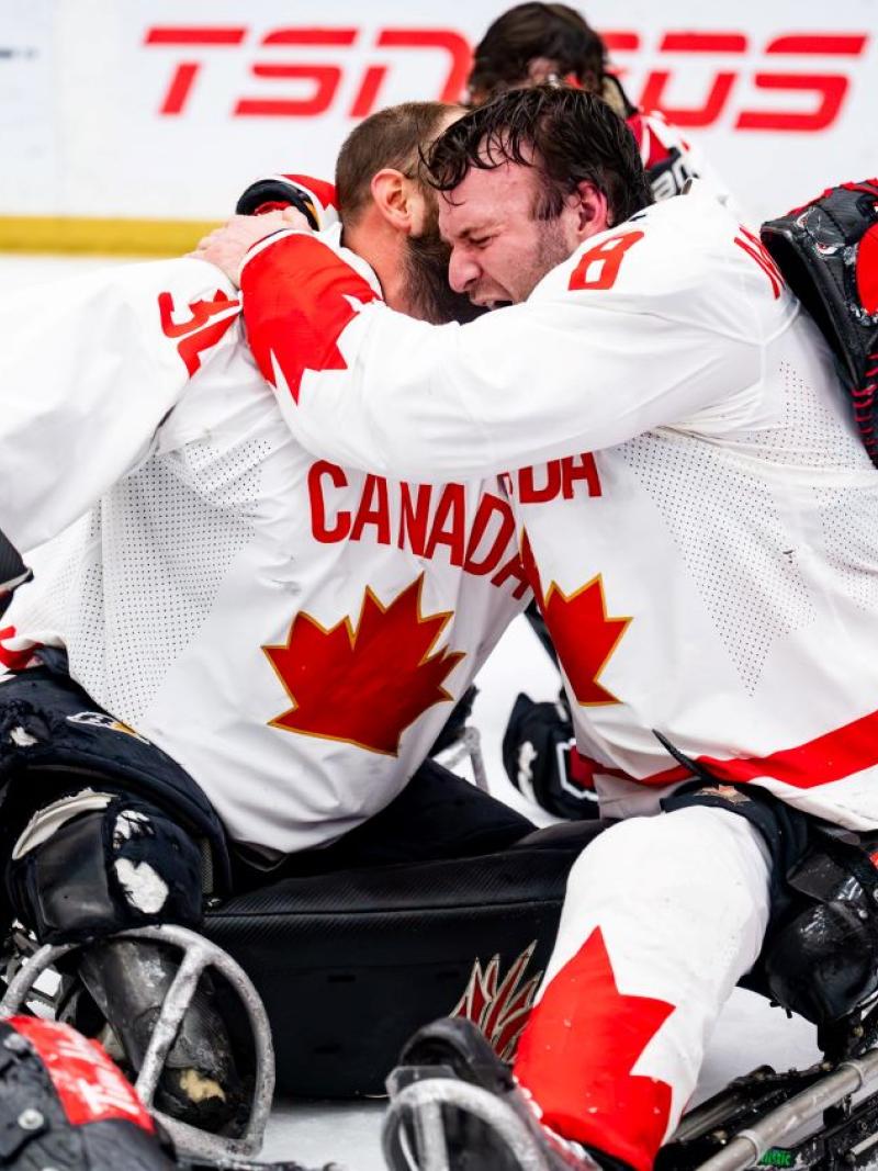 A group of Canadian Para ice hockey players celebrating on ice