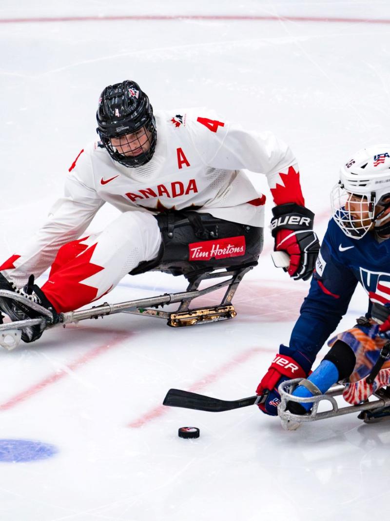 A Para ice hockey player from USA against a player from Canada