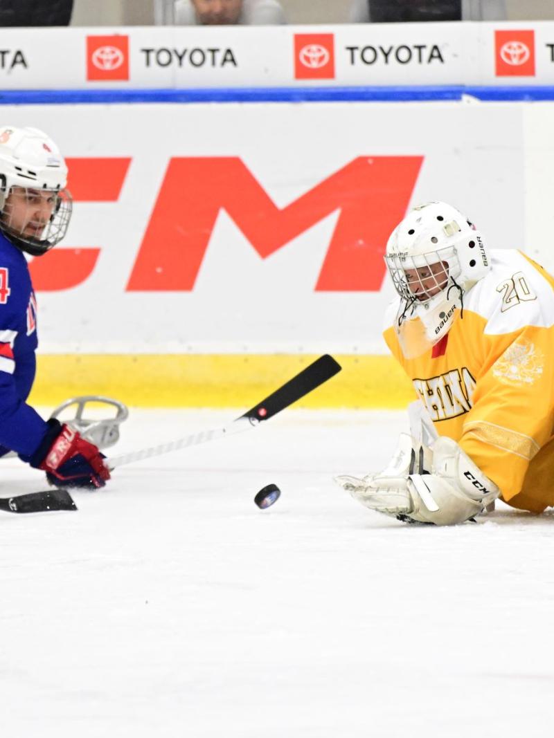 A Team USA Para ice hockey player against two Chinese players