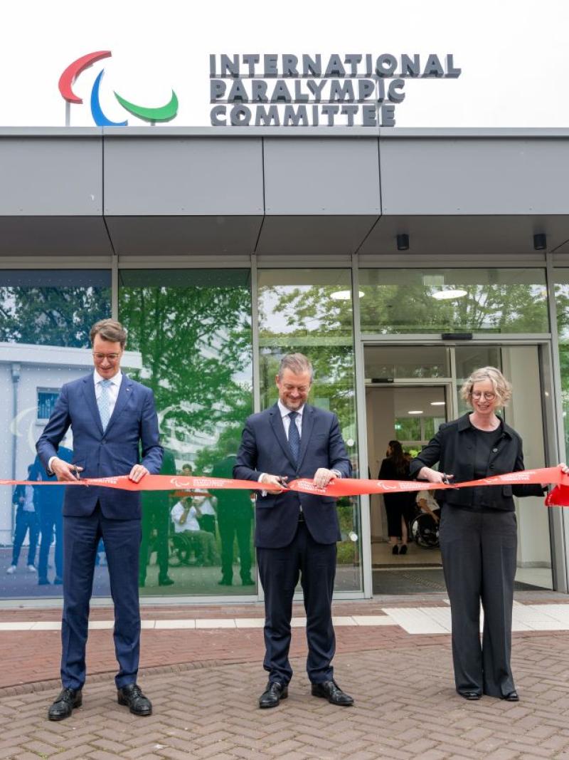 Four officials (three male and one female) cut a red ribbon in front of the new IPC Campus