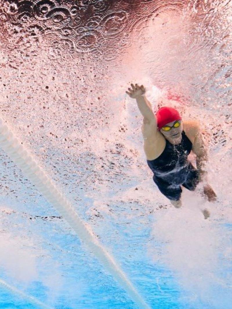 An underwater photo of three female Para swimmers