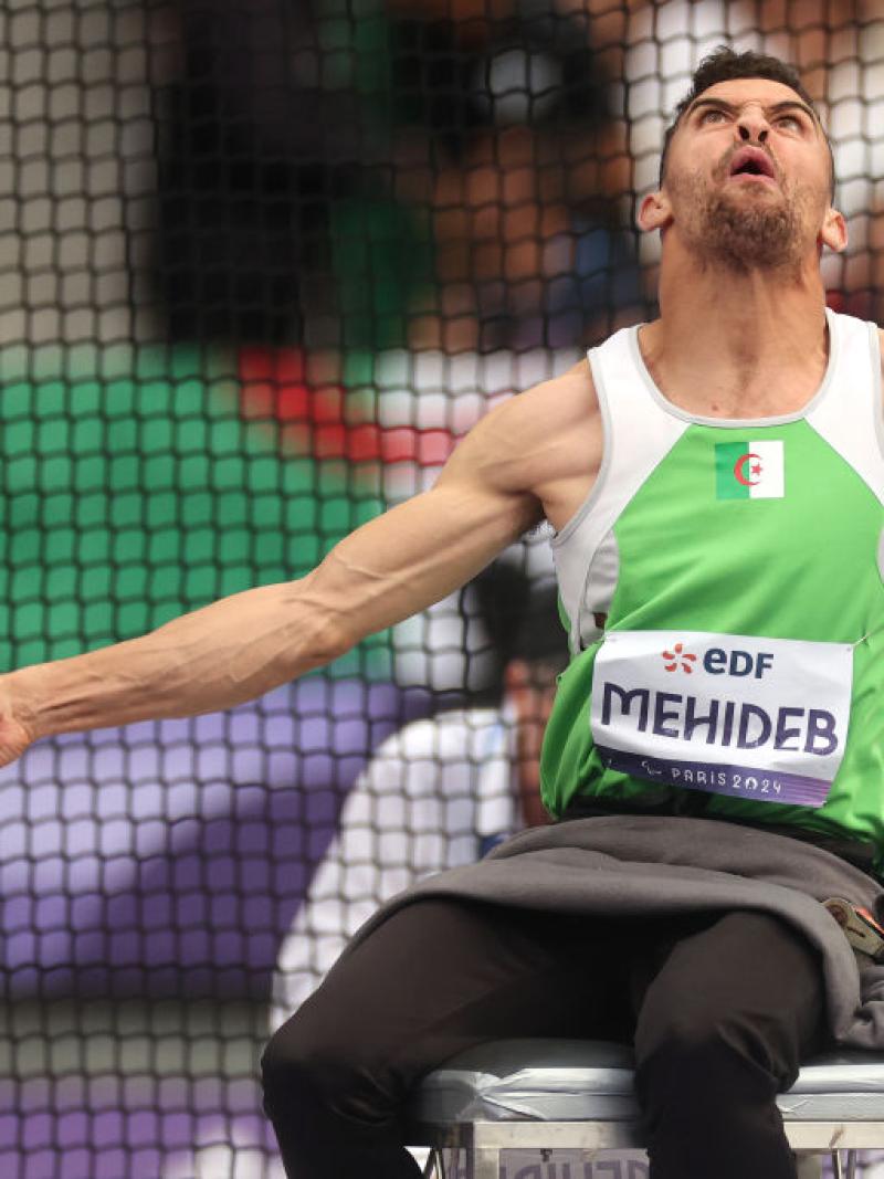 A male athlete competing in the club throw 