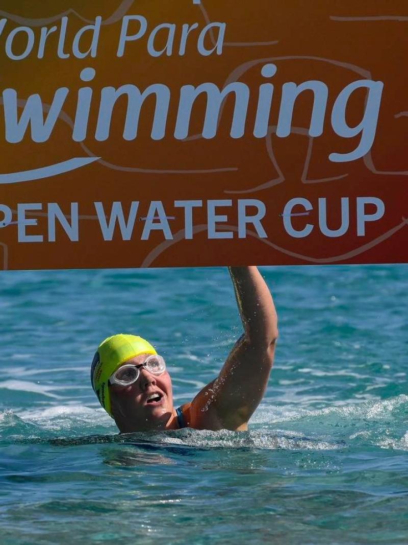A female swimmer hitting the board at the finish line of the World Para Swimming Open Water Cup