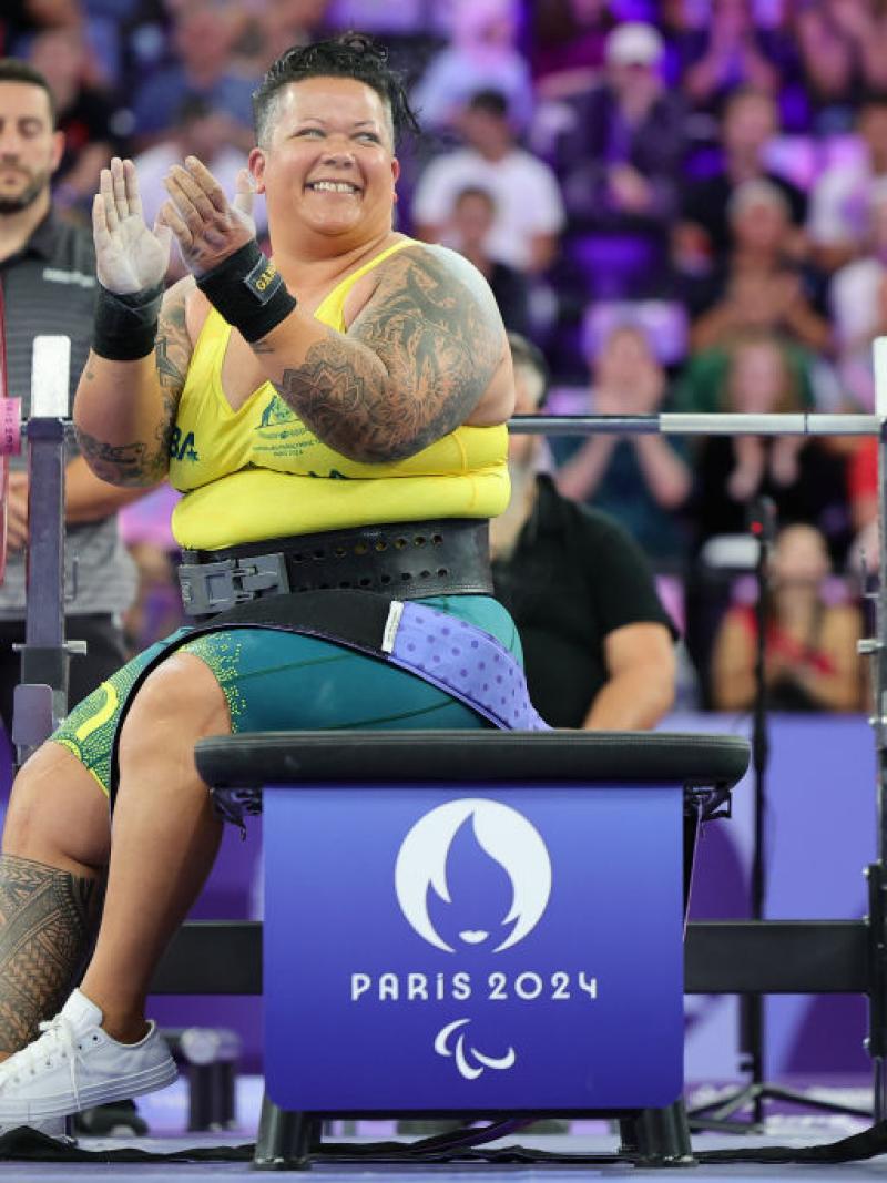 A female powerlifter clapping hands on the bench press at Paris 2024
