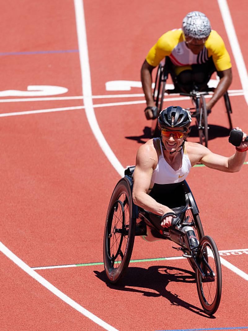 A female wheelchair racer celebrating with another racer behind her