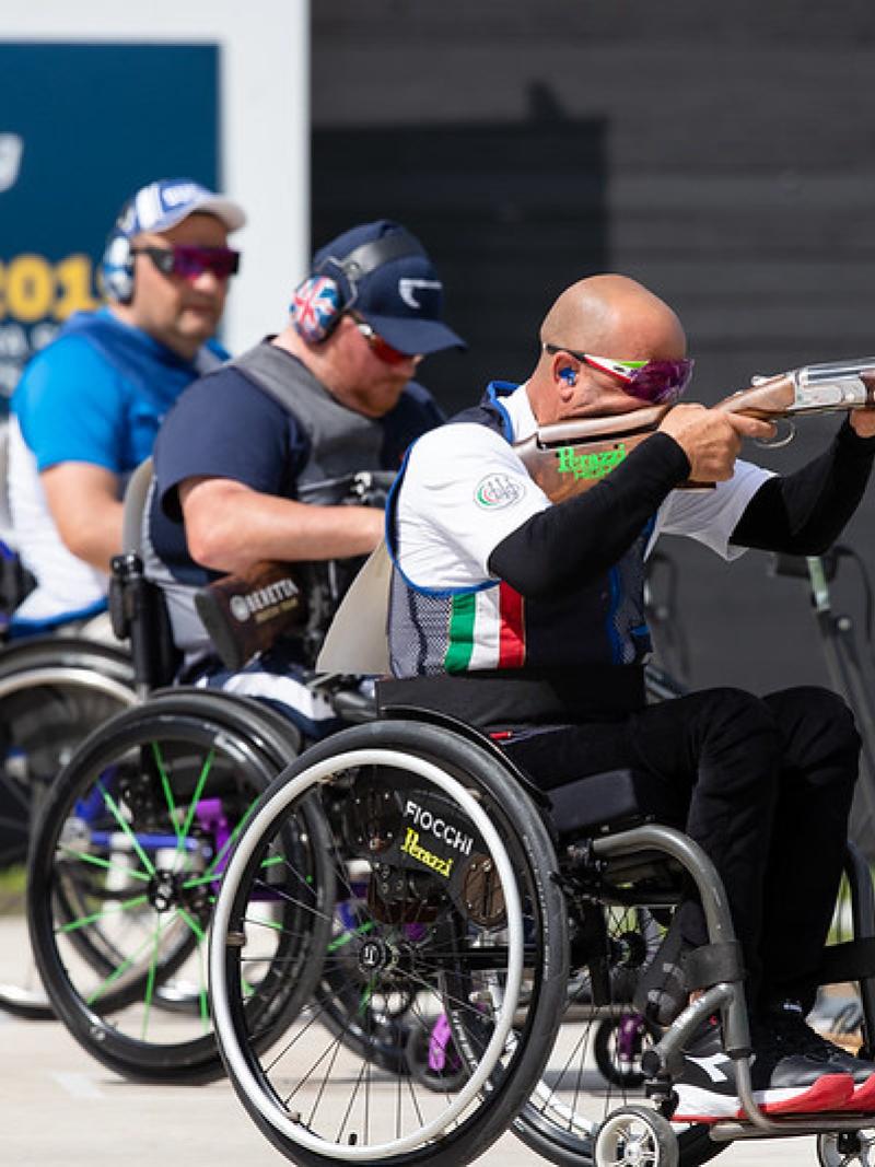 Three men in wheelchairs competing in Para trap shooting