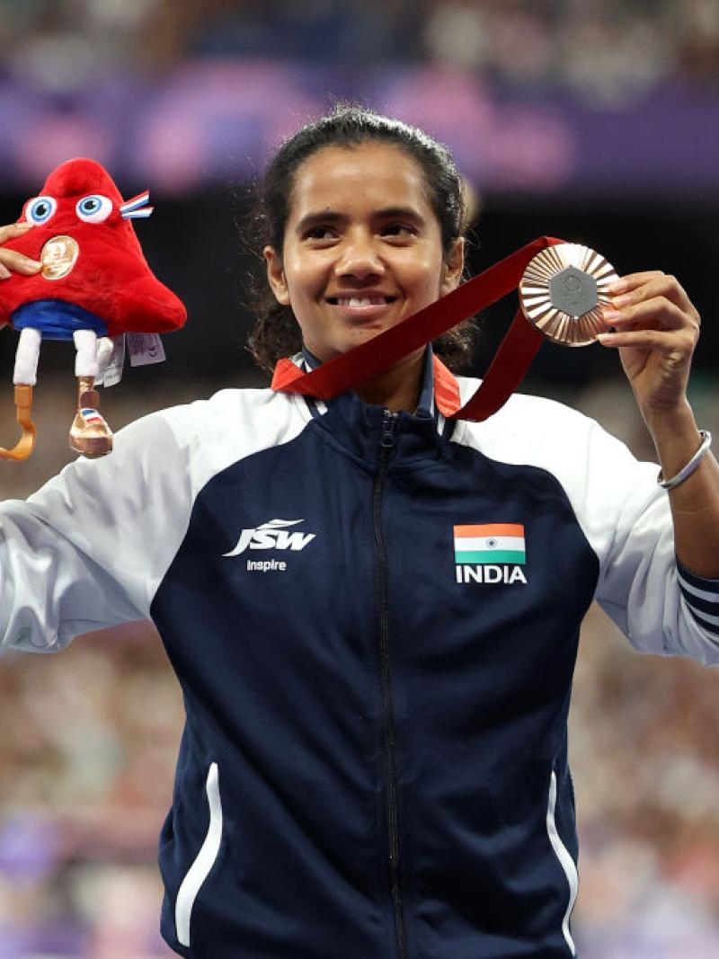 A female athlete with the uniform of India showing a silver medal at Paris 2025
