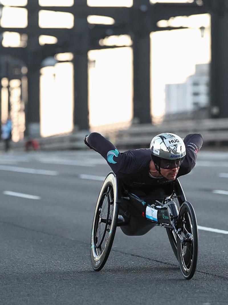 A male wheelchair racer crossing a bridge