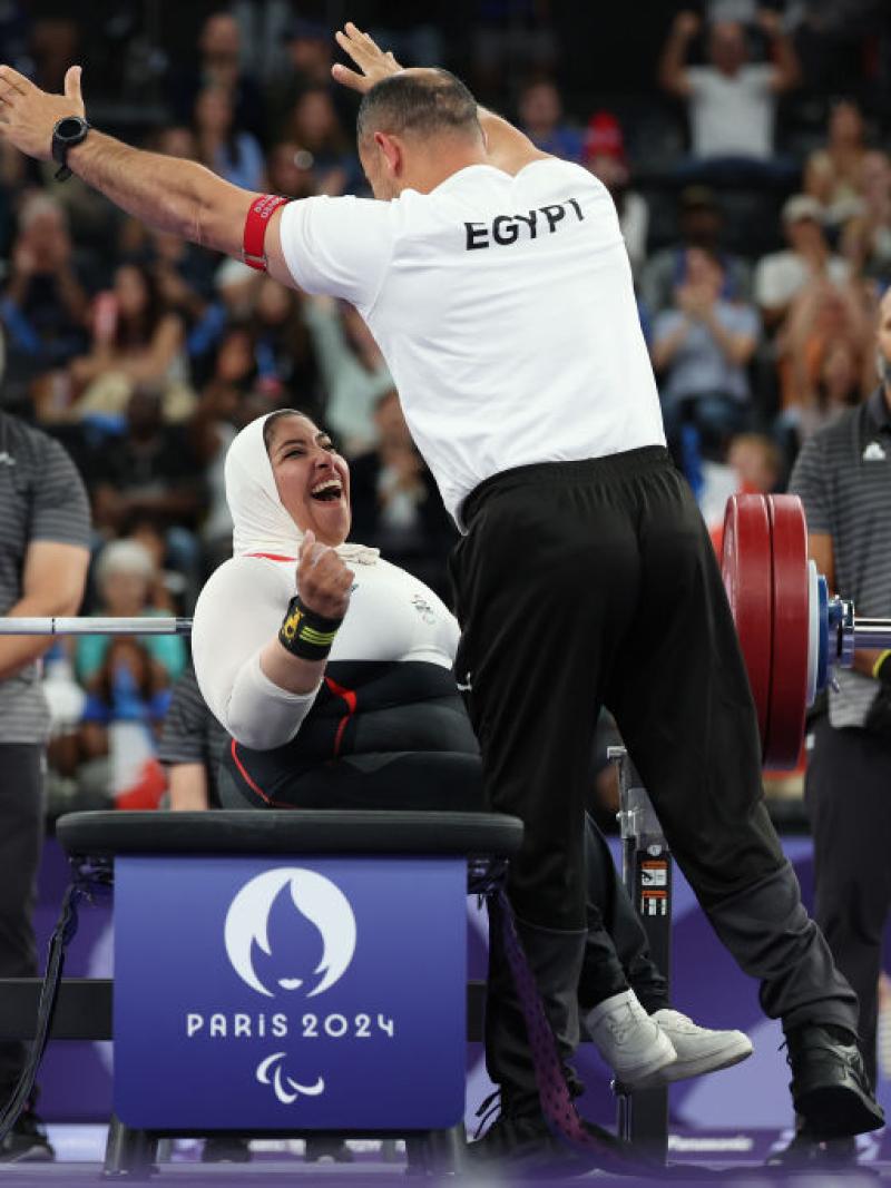A female Egyptian Para powerlifter celebrates with her coach after her lift at Paris 2024