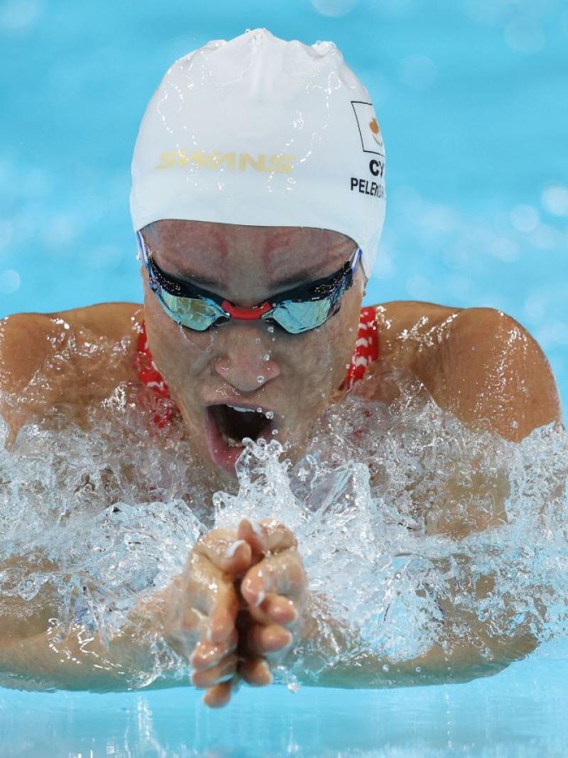 A female athlete with blackened goggles swimming breaststroke