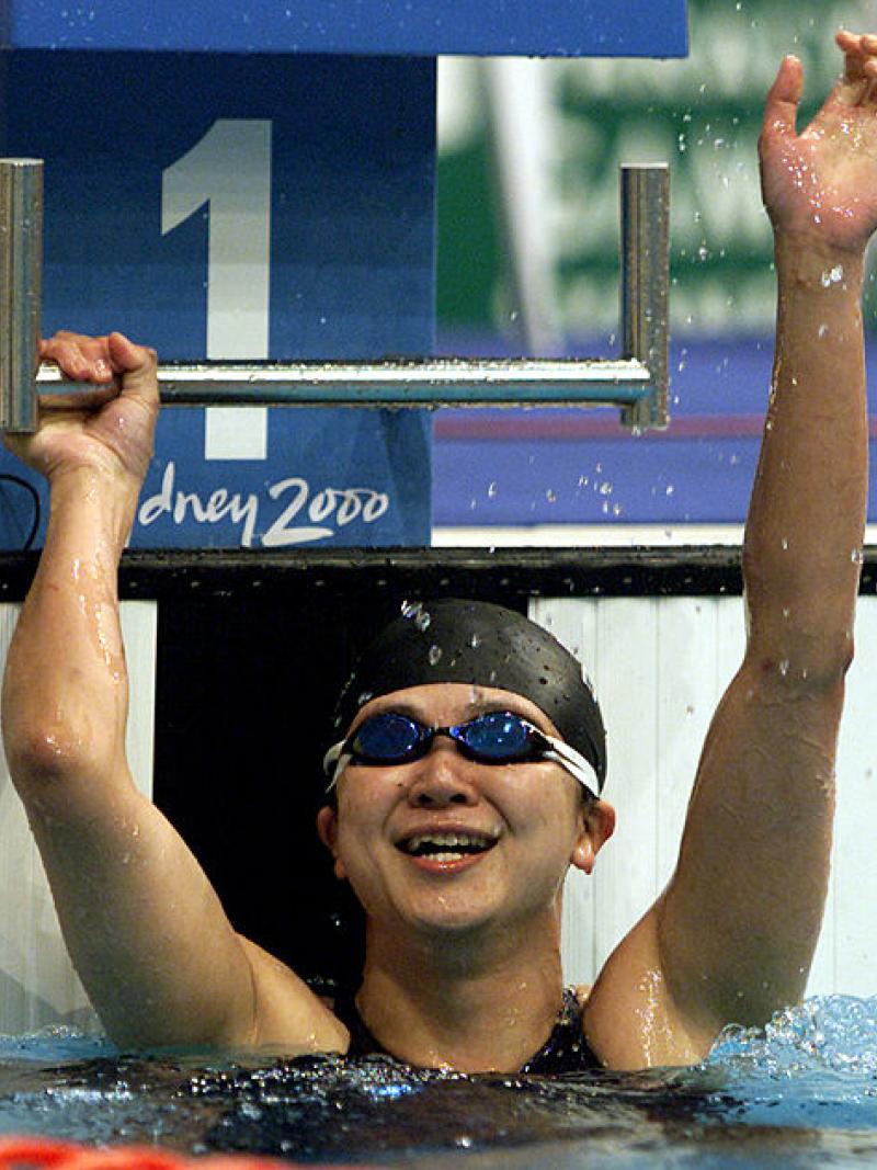 A female swimmer waving from the swimming pool at the Sydney 2000 Paralympic Games